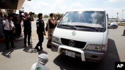 A van carries four refugees from Phnom Penh International Airport on June 4, 2015. They were part of an earlier refugee deal with Australia.