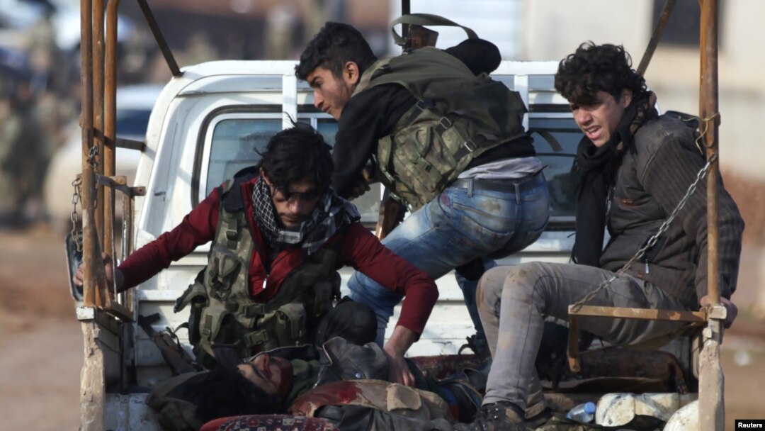 Pejuang Angkatan Darat Suriah menaiki truk pick-up dengan seorang rekan tempur yang terluka dalam serangan di pinggiran kota Suriah utara, Al-Bab, 10 Januari 2017.