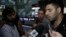 U.S. journalist Glenn Greenwald (C) looks on as his partner David Miranda (R) talks with the media after arriving at Rio de Janeiro's International Airport, August 19, 2013.