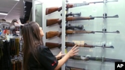 Salesperson Lauren Ungari checks rifles in a display in a gun shop in Sydney, Australia, Oct. 4, 2017. Australia recently concluded a three-month gun amnesty period that collected more than 51,000 guns.