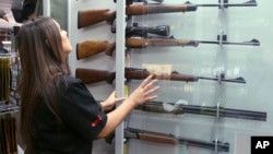 Salesperson Lauren Ungari checks rifles in a display in a gun shop in Sydney, Australia, Oct. 4, 2017. Australia recently concluded a three-month gun amnesty period that collected more than 51,000 guns.