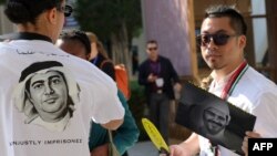 FILE - An Amnesty International activist wears a t-shirt bearing a picture of imprisoned UAE human rights activist and poet Ahmed Mansoor as another holds a portrait of imprisoned UAE democracy advocate Mohammed al-Siddiq, at the UN climate summit in Dubai on December 9, 2023.