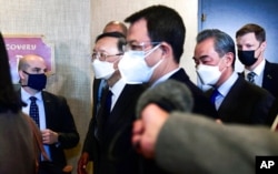 FILE - Top Chinese diplomat Yang Jiechi, second from left, and Chinese Foreign Minister Wang Yi, second from right, depart from the closed-door morning session of U.S.-China talks in Anchorage, Alaska, March 19, 2021.