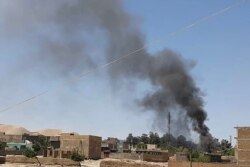 FILE - A plume of smoke rises amid ongoing fighting between Afghan security forces and Taliban insurgents in the western city of Qala-e-Naw, the capital of Afghanistan's Badghis province, July 7, 2021.