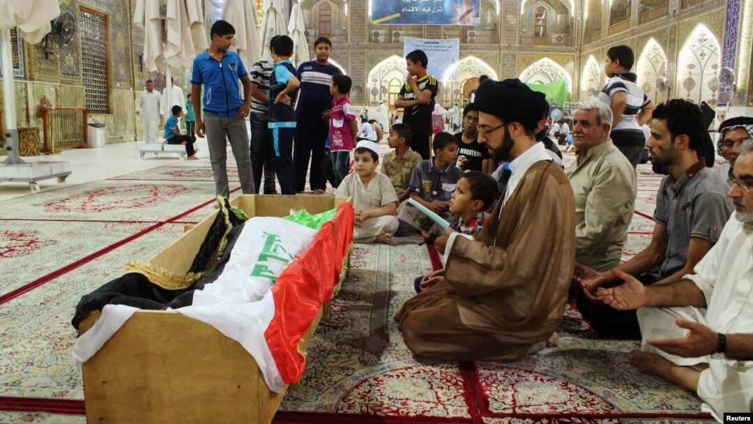 Warga Irak melakukan upacara pemakaman atas korban tewas dalam serangan militan terhadap penjara Taji, di pinggiran kota Baghdad (22/7).