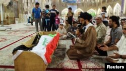 Mourners pray at the coffin of a victim killed during an attack on a prison in Taji, during a funeral at the Imam Ali shrine in Najaf, 160 km (100 miles) south of Baghdad, July 22, 2013. 