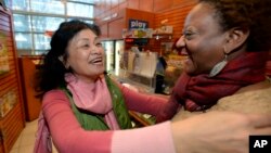Young Soo Lee, dueña de una de las tiendas en donde se vendió uno de los billetes ganadores, en Atlanta, celebra la noticia. El establecimiento recibirá un premio de $1 millón de dólares.