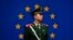 FILE - A Chinese policeman stands in front of the European Union flag outside the office of the European Union delegation to China in Beijing, Oct. 28, 2011. 
