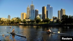 FILE - Rowers train at dawn on the Yarra River in Melbourne, Australia, Jan. 24, 2012. 