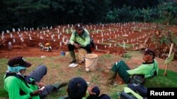 Para petugas penggali kuburan beristirahat di sebuah kompleks pemakaman yang disediakan pemerintah untuk jenazah pasien Covid-19, di Jakarta, 22 April 2020. (Foto: Reuters)