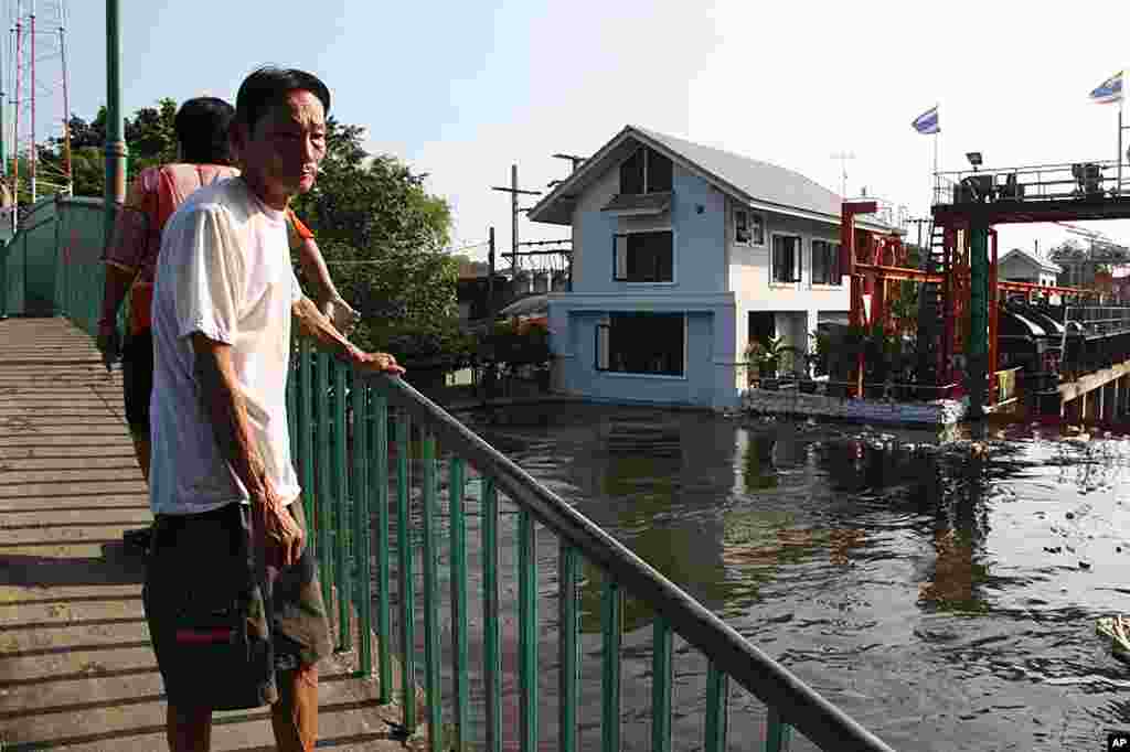 People looking at the Chao Phraya River from a bridge, October 27, 2011. (VOA - D. Schearf)