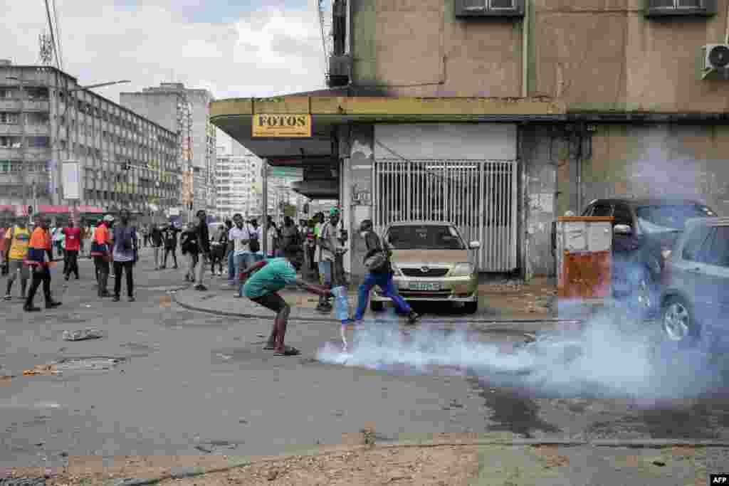 Um manifestante atira água em uma lata de gás lacrimogéneo disparada pela polícia enquanto os manifestantes entram em confronto com a polícia de choque moçambicana em Maputo, em 27 de novembro.