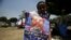 A boy holds a defaced poster of Egyptian President Mohamed Morsi outside his family's tent in front of the Ministry of Defense, Cairo June 25, 2013. 