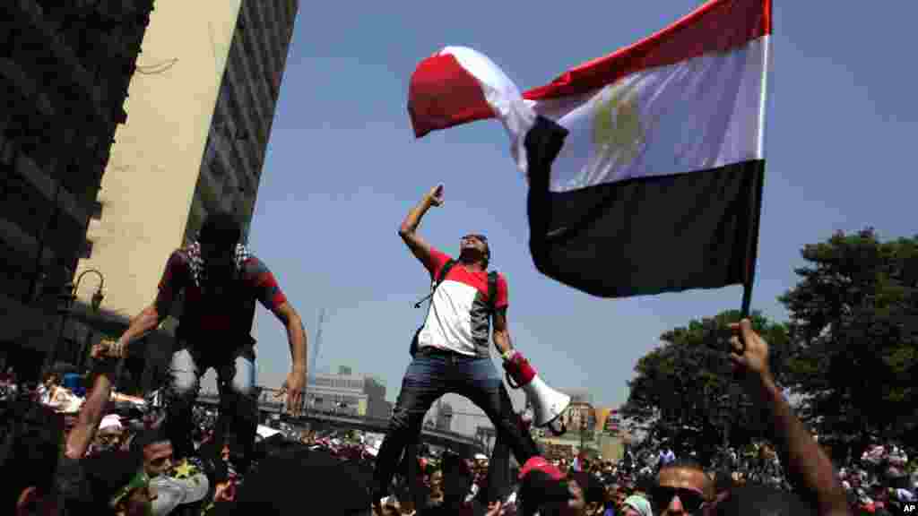 A girl looks from a car window with a 'wanted' poster of Abdel Fattah al-Sisi (R), the army chief who ousted Egypt's president Mohamed Morsi (L poster), as she joins a a rally against the crackdown on protesters in Egypt in central London on August 17, 20