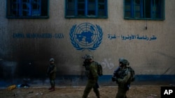 FILE - Israeli soldiers take position as they enter the UNRWA headquarter during a ground operation in Gaza, Thursday, Feb. 8, 2024.