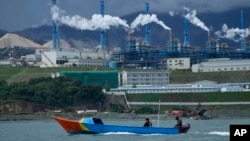 Perahu warga tampak melintasi perairan di dekat kawasan industri Weda Bay di Halmahera tengah, Maluku Utara, pada 8 Juni 2024. (Foto: AP/Achmad Ibrahim)