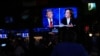 People watch TV screens showing the debate between Democratic presidential nominee Vice President Kamala Harris, right, and Republican presidential nominee former President Donald Trump at Sports Grill Kendall in Miami, Florida, Sept. 10, 2024. 