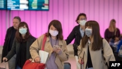 Penumpang memakai masker untuk melindungi dari penyebaran virus korona ketika mereka tiba di Bandara Internasional Los Angeles, California, 22 Januari 2020. (Foto: AF)