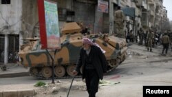 A Kurdish elderly man walks with a cane in Afrin, Syria, March 19, 2018.