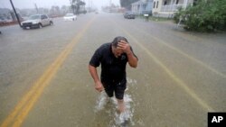 Angel Marshman wades through floodwaters after trying to start his flooded car in Galveston, Texas, Sept. 18, 2019.