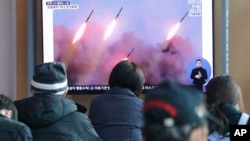 People watch a TV showing file images of North Korea's missile launch during a news program at the Seoul Railway Station in Seoul, South Korea, Monday, March 10, 2020. 