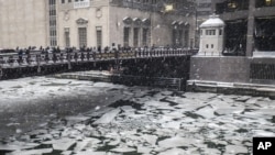 Peatones cruzan un río helado en Madison St., cerca del Civic Opera House en Chicago, el lunes.