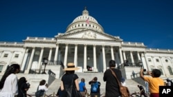 People view the flag-draped casket of Rep. John Lewis, D-Ga., as he lies in state on the East Front Steps of the Capitol in Washington, July 27, 2020.