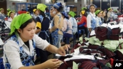 FILE PHOTO - Cambodian garment workers work inside a factory in Phnom Penh, Cambodia, May 10, 2004. 