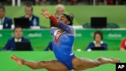 L’Américain Simone Biles en plein numéro lors de la finale de la gymnastique artistique féminine aux Jeux Olympiques d'été de 2016 à Rio de Janeiro, au Brésil, 16 août 2016. 