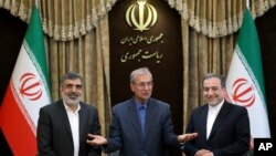 FILE - From left to right, spokesman for Iran's atomic agency Behrouz Kamalvandi, Iran's government spokesman Ali Rabiei and Iranian Deputy Foreign Minister Abbas Araghchi, attend a press briefing in Tehran, July 7, 2019.