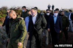 U.S. Secretary of State Mike Pompeo is accompanied by Israeli Foreign Minister Gabi Ashkenazi as they arrive for a security briefing on Mount Bental in the Israeli-occupied Golan Heights, Nov. 19, 2020.