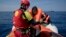 FILE - Proactiva Open Arms lifeguard Ivan Martinez, from Spain, rescues migrants from a rubber boat sailing out of control, in the Mediterranean sea, about 56 miles north of Sabratha, Libya, April 6, 2017. 