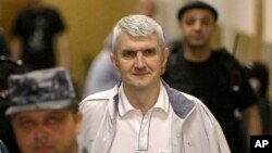 FILE - In this June 3, 2011 file photo, former Yukos CEO Mikhail Khodorkovsky's co-defendant Platon Lebedev, surrounded by guards, walks to a courtroom in Moscow. 