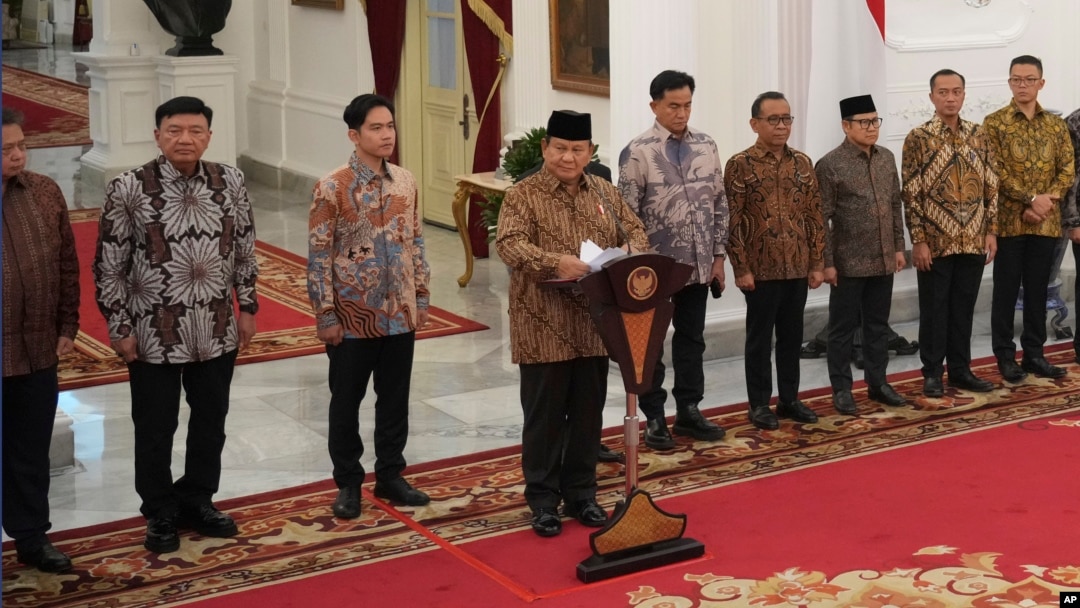 Presiden baru Indonesia Prabowo Subianto, tengah, mengumumkan susunan kabinet menteri yang baru dilantik, di Istana Merdeka, di Jakarta, Minggu 20 Oktober 2024.