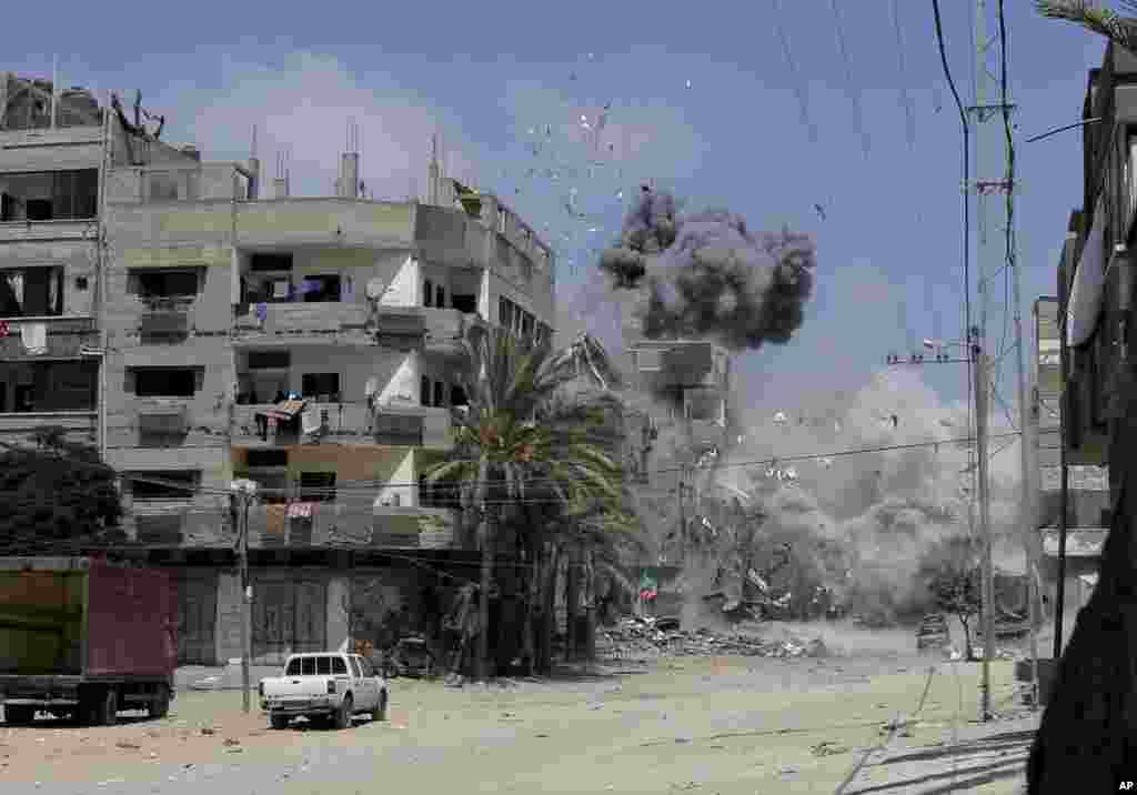 Smoke and dust rise after an Israeli strike on a three-story building belonging to the Abdul Hadi family in Gaza City in the northern Gaza Strip, Aug. 24, 2014. 