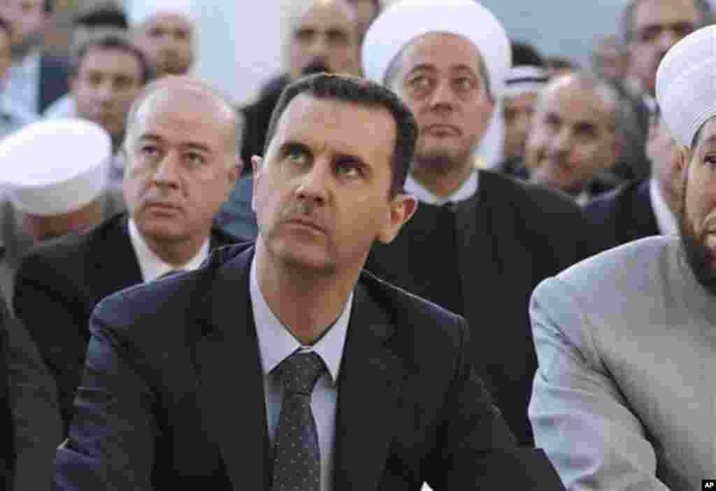 Presiden Suriah Bashar al-Assad menghadiri sholat Idul Fitri di masjid Al-Hamad di Damaskus, Suriah, Minggu (19/8).