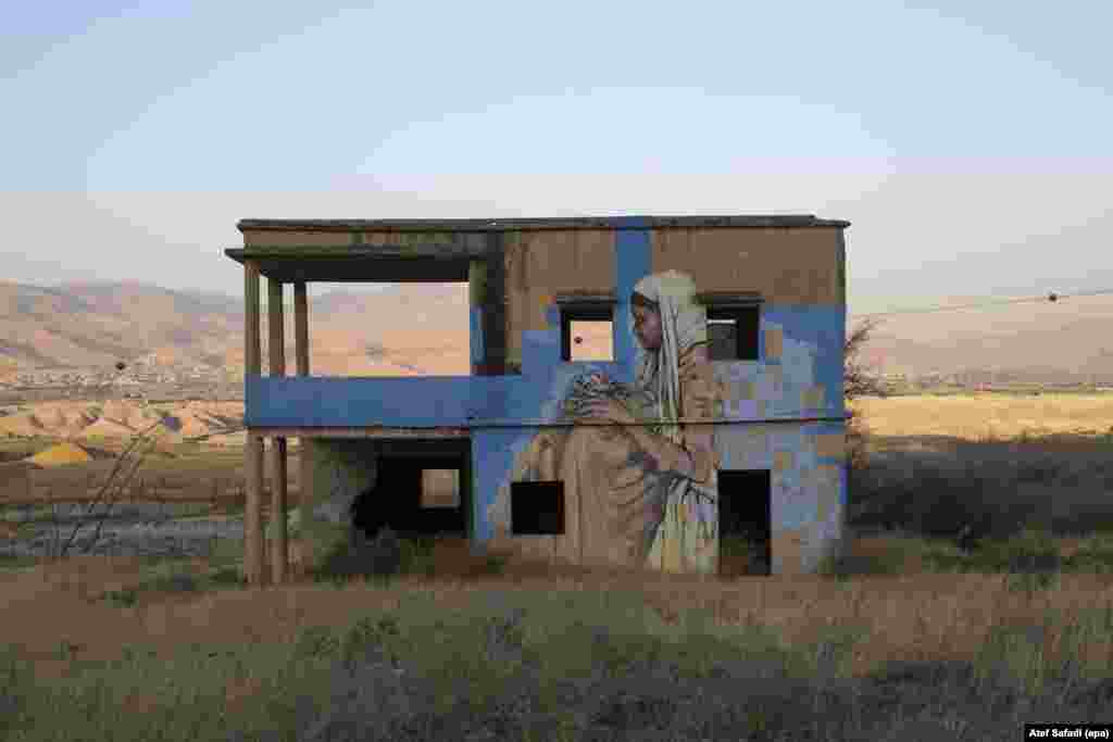 A mural and graffiti by unknown artists are seen on an abandoned building used to be a water pump from the Jordan River, in the Jordan Valley, Israel, June 22, 2016.