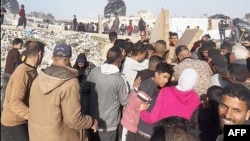 In this image grab from an AFPTV video, people gather around food parcels that were airdropped from US aircraft above a beach in the Gaza Strip on March 2, 2024.