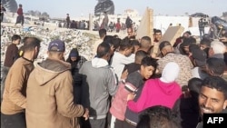 Foto dari tangkapan cuplikan video AFPTV itu tampak orang-orang berkumpul di sekitar paket makanan yang dijatuhkan dari pesawat AS di atas pantai di Jalur Gaza pada 2 Maret 2024. (Foto: AFP)