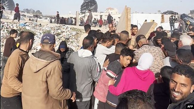 Foto dari tangkapan cuplikan video AFPTV itu tampak orang-orang berkumpul di sekitar paket makanan yang dijatuhkan dari pesawat AS di atas pantai di Jalur Gaza pada 2 Maret 2024. (Foto: AFP)