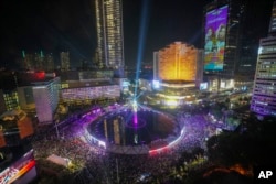 Warga berkumpul di kawasan bisnis utama pada malam tahun baru di Jakarta, Indonesia, Selasa, 31 Desember 2024. (Tatan Syuflana/AP Photo)