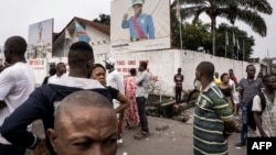 Des badauds regardent des manifestants lors d'une marche contre Kabila, à Kinshasa, le 21 janvier 2018.