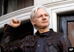 Pendiri WikiLeaks Julian Assange menyapa para pendukungnya di luar kedutaan Ekuador di London, tempat dia diasingkan sejak 2012. (Foto: AP)