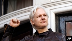 FILE - In this May 19, 2017 photo, WikiLeaks founder Julian Assange greets supporters outside the Ecuadorian embassy in London, where he has been in self imposed exile since 2012. 