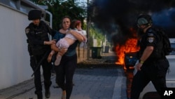 Arhiva - Policija evakuiše ženu i dete u južnom Izraelu, tokom napada Hamasa, 7. oktobra 2023.