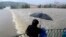A family watches the swollen Vltava river in the center of Prague, Czech Republic, June 2, 2013. 