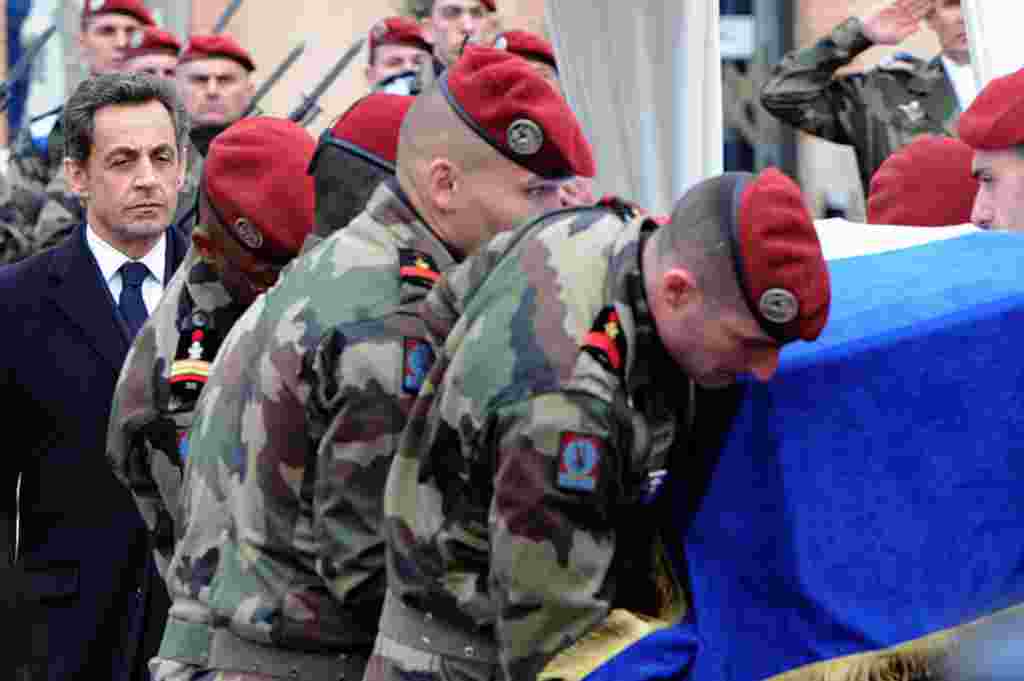 Presiden Perancis Nicolas Sarkozy (kiri) mendampingi para tentara yang mengangkut peti jenazah salah seorang aparat keamanan Perancis yang terbunuh di tangan penembak di Mountaban. Mohamad Merah merupakan tersangka utama pelaku penembahakan (AFP).