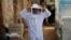 A beekeeper adjusts his protective gear at his farm in Shibin El Kom, Menoufia province, northeast of Cairo, Egypt, Nov. 30, 2016.