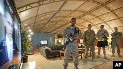 Spc. Gavin Fruge, 22, of Crowley, La., left, watches a rebroadcast of President Barack Obama's speech on proposed troop withdrawal with fellow soldiers at Kandahar Airfield in Kandahar, Afghanistan, June 23, 2011 (file photo)