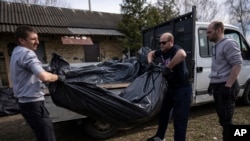 人们在基辅近郊布查把被杀害的平民遗体抬上卡车。(2022年4月7日)